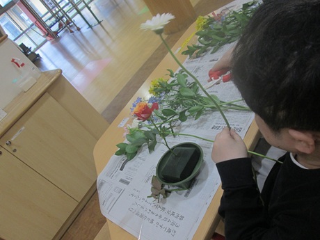 フラワーサークルにて花を手に取り長い部分を切っている